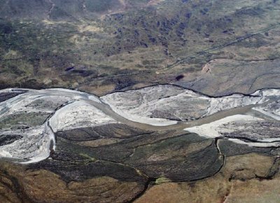 Rio trançado e cicatrizes de estradas no verão