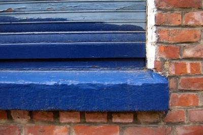 Muro di mattoni e una finestra blu