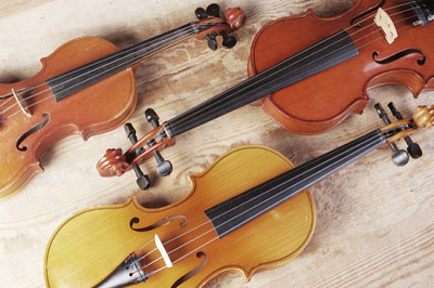 Três violinos em textura de madeira