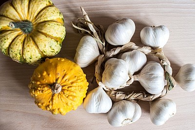 Abóboras, alho e abóboras em uma mesa de madeira