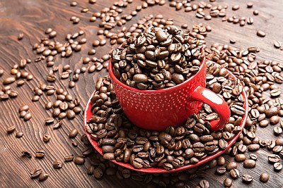 rote Tasse mit Kaffeebohnen gefüllt