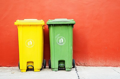Grandes lixeiras verdes e amarelas para reciclagem
