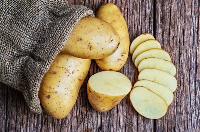 Patatas orgánicas crudas en el saco
