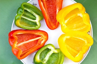 Cut in halves clourful peppers slices on a plate