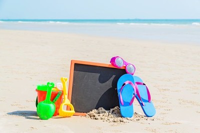 Chinelo, óculos de sol, brinquedos infantis na praia