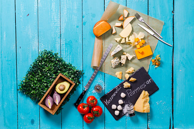 Different types of cheese on a blue wooden table