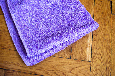Colorful bent towel on wooden background: purple c