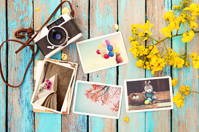 Retro camera and paper photo album on wood table w