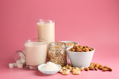 Assortment of tasty vegan milk on color background