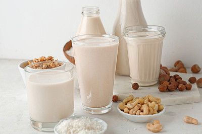 Assortment of tasty vegan milk on light table