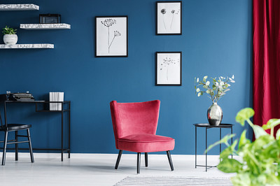 Red armchair in blue living room interior with wor