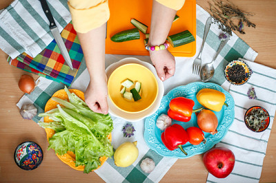 the woman is preparing a salad of vegetables. heal