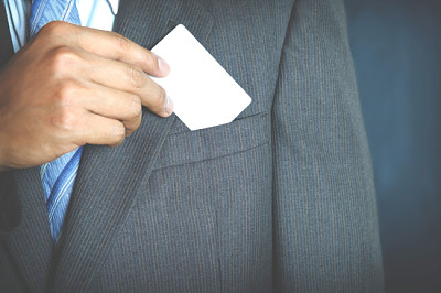 Young businessman holding white business card and 