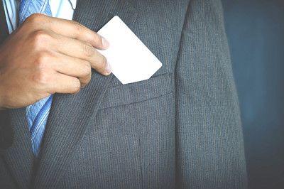 Jeune homme d'affaires détenant une carte de visite blanche et