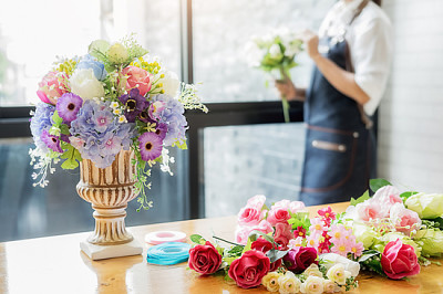 Kvinna händer som gör blomma sammansättning hos florist w