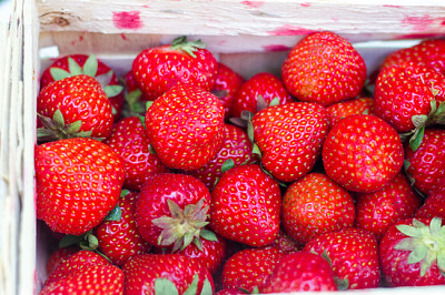 Fresh bright red strawberries in a wooden basket o
