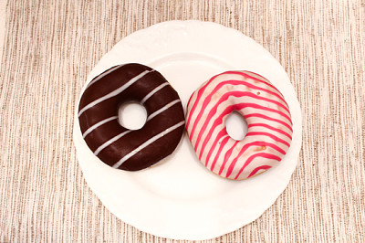 Pink and brown stripped donuts on plate on grey fa jigsaw puzzle