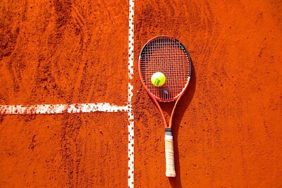 Pelota de tenis en raqueta de tenis en el piso