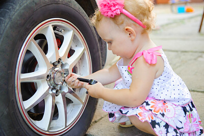 Bambino che ripara un'auto vera