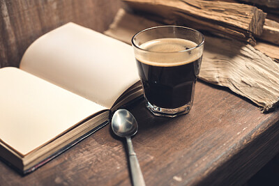 Glas Kaffee mit einem alten Buch