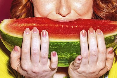 Frau beißt in eine Scheibe Wassermelone