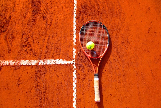 Balle de tennis sur une raquette de tennis au sol
