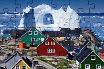 Costal Homes in Greenland as an Iceberg floats by