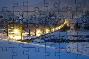 Puente nevado con luces en invierno jigsaw puzzle