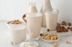 Assortment of tasty vegan milk on light table
