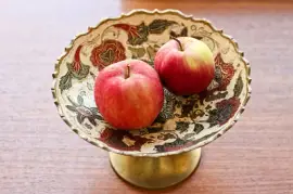 Maçãs em tigela metálica decorada com flores orn