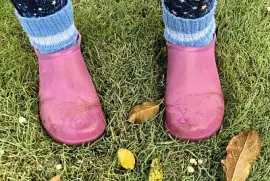 Pink boots in autumn garden