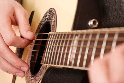 Close de tocar guitarra