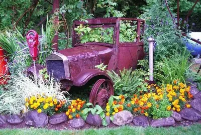 Rusty Car parked between the Flowers