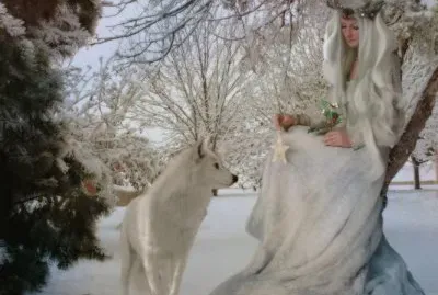 Lobo con mujer vestida de blanco en invierno