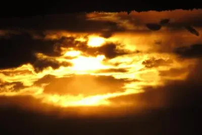 Setting sun peeking through dark clouds