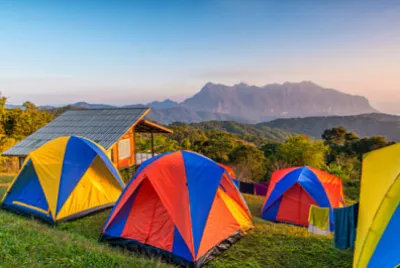 Campingtält på bergstoppen under soluppgången