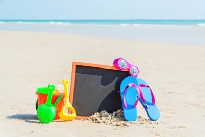 Infradito, occhiali da sole, giocattoli per bambini sulla spiaggia