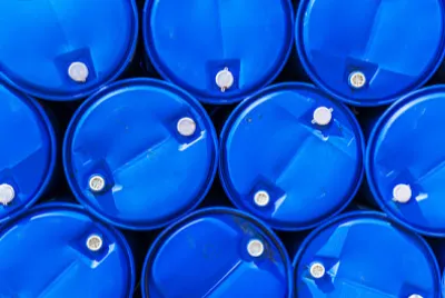 Barili di sostanze chimiche blu accatastati.