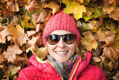 Vacker kvinna som ligger i färgglada höstlöv