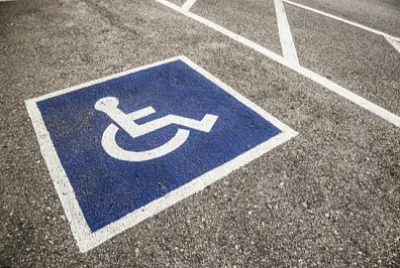 Simbolo di portatori di handicap dipinto su un posto di parcheggio