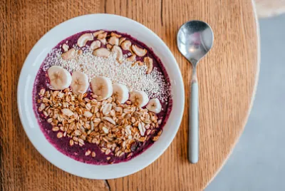 Bella ciotola di frullato di banana e mirtillo con una sp