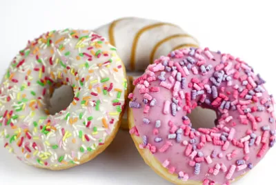 白い背景の上のカラフルなおいしいドーナツ。緑、