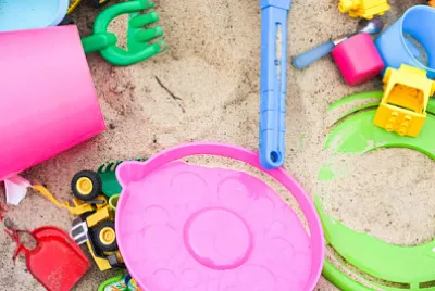 Juguetes coloridos en el arenero. Infancia feliz, camino