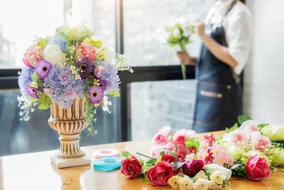 Mãos de mulher fazendo composição de flores na florista w