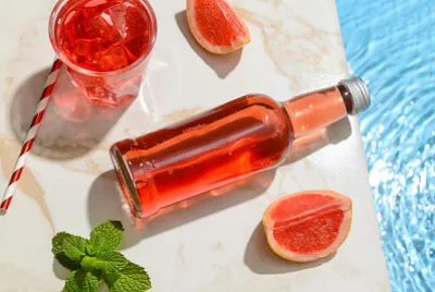 Eine Flasche frisches Grapefruit-Soda in der Nähe des Pools