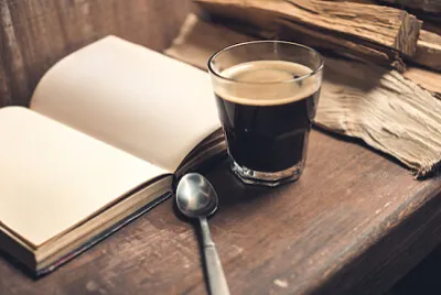 Ett glas kaffe med en gammal bok