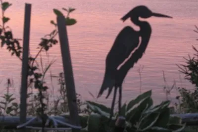 Bird figure overlooking river sunset