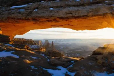The sun peeks through Mesa Arch in Canyonlands Nat
