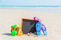 Flip flop, sunglasses, children toys on the beach
