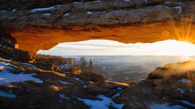 The sun peeks through Mesa Arch in Canyonlands Nat